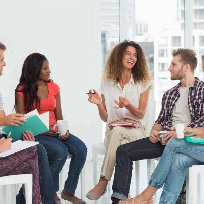 Smiling therapist speaking to a rehab group at therapy session